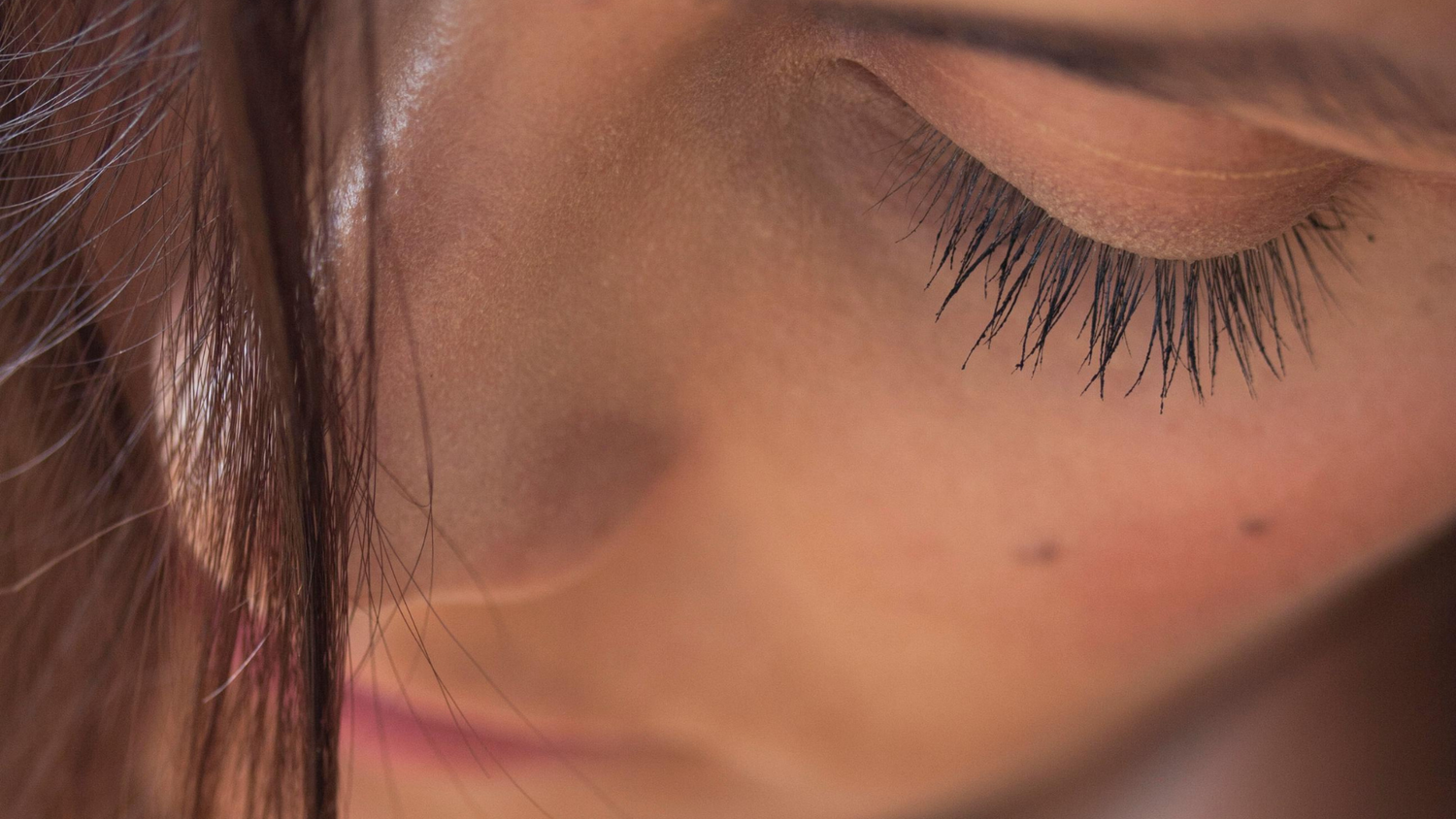 Vrouw met mooie wimpers door de elektrische wimperkruller