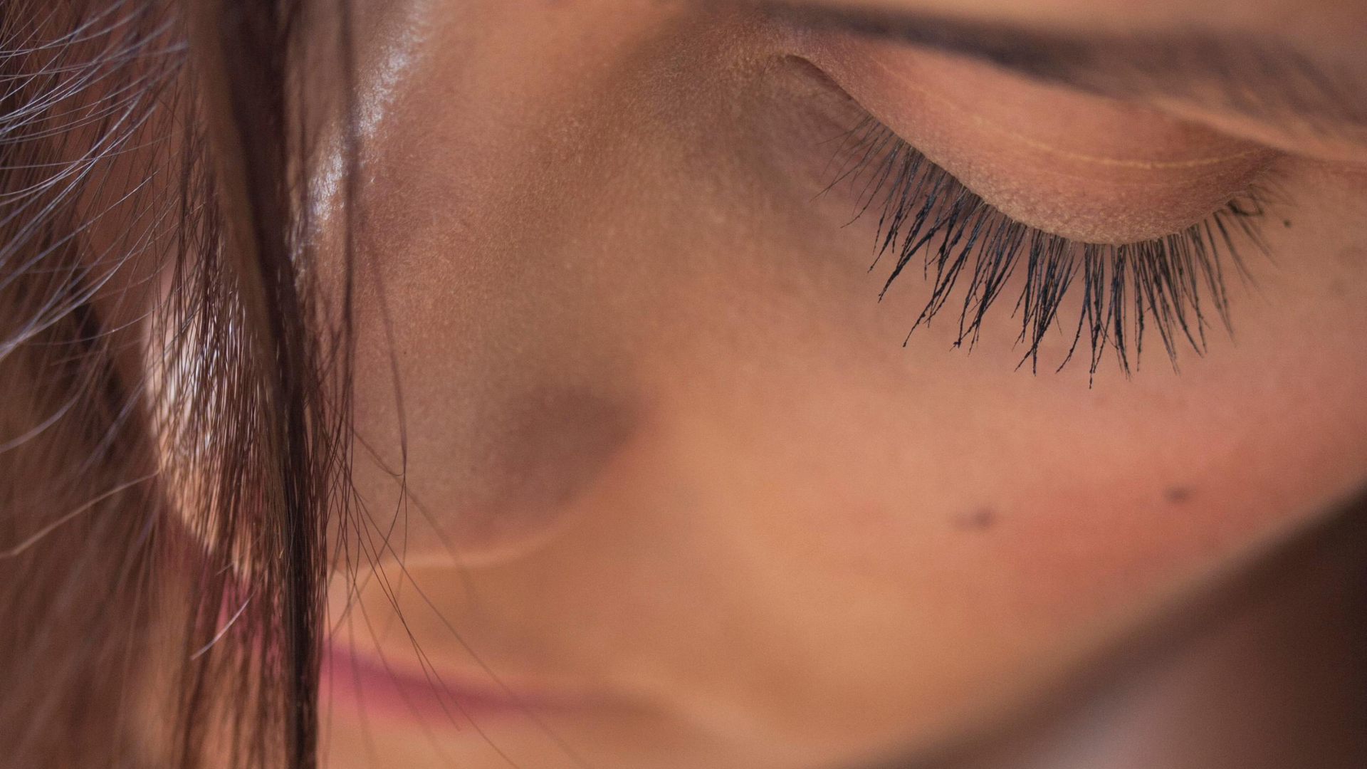 Vrouw met mooie wimpers door de elektrische wimperkruller
